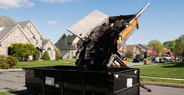 An Equipter 4000 depositing debris into a rolloff dumpster