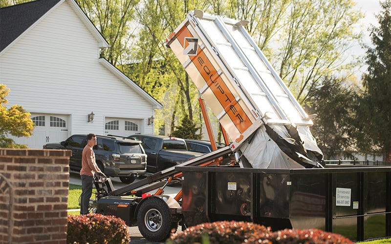 The Equipter 4000 dumping roofing debris into a dumpster