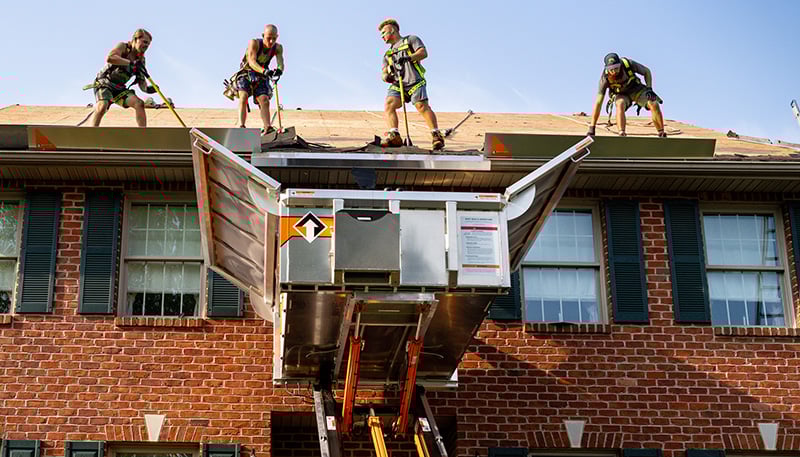 A roofing crew works on a tear-off with an Equipter 4000