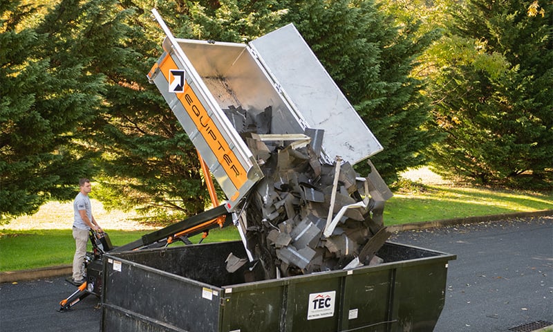 The Equipter 4000 dumping shingles into a roll-off dumpster