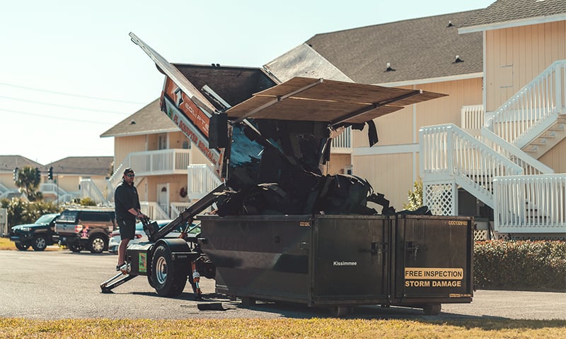The Equipter 4000 dumping roofing debris into a dumpster
