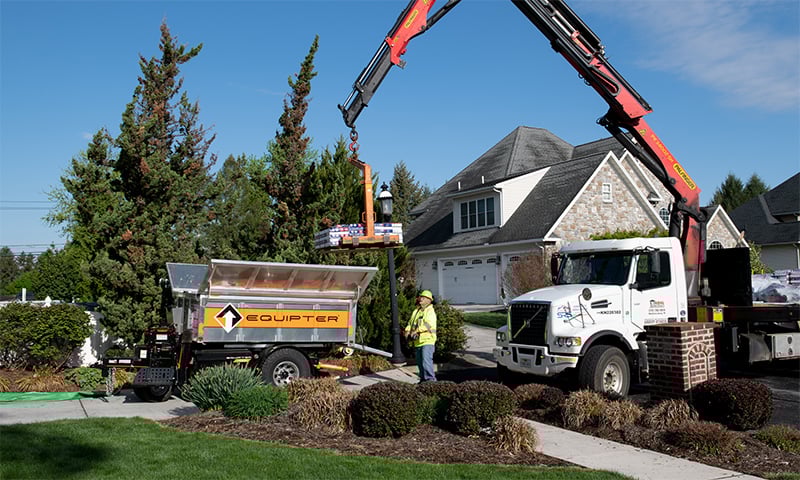 A supply truck loading shingle packs into an Equipter 4000