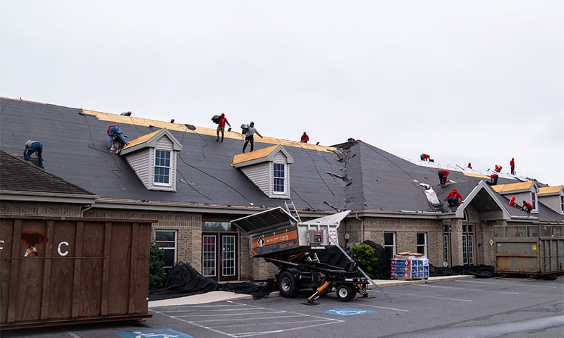 A crew using the Equipter 4000 to capture shingles on a commercial roofing project