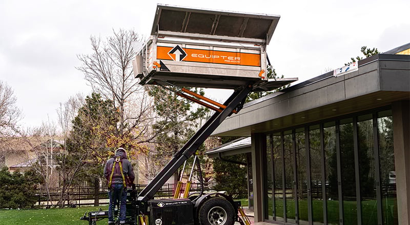 Equipter 4000 with its container lifted on a commercial roofing site