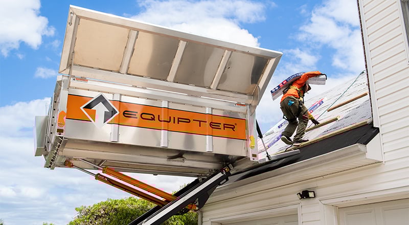 Crew taking shingle bundles to a roof with an Equipter 4000