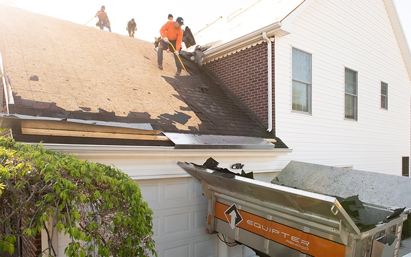 A crew tearing off a roof with an Equipter 4000